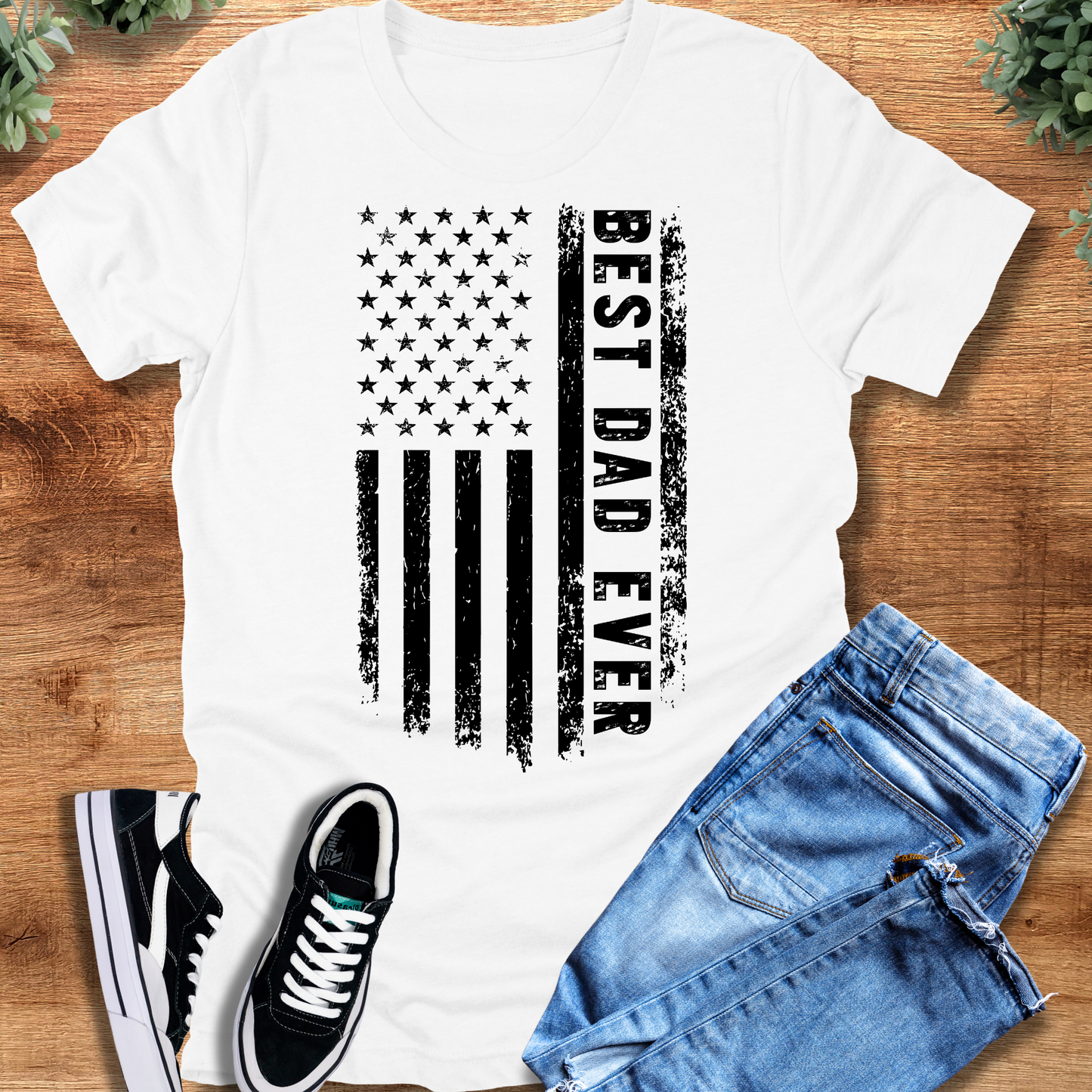 Black t-shirt with '' text, flat lay styled on a wooden surface.