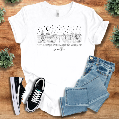 White t-shirt with 'If The Stars Were Made To Worship, So Will I T‑Shirt' text, flat lay styled on a wooden surface.