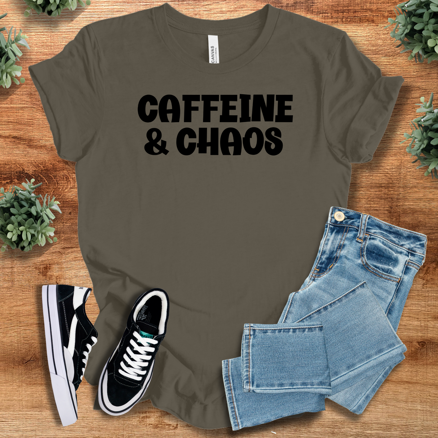 Black t-shirt with '' text, flat lay styled on a wooden surface.