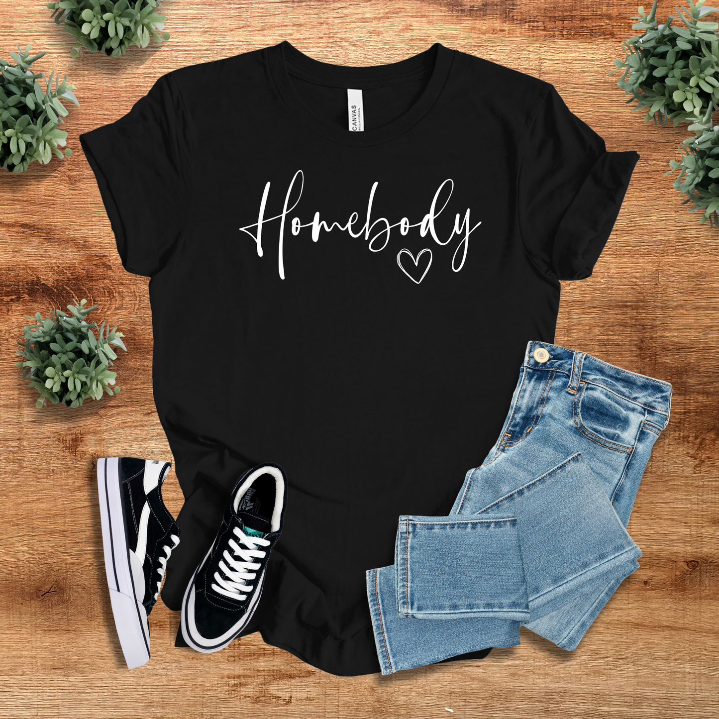 Black Homebody Graphic T-Shirt with minimalist script design, paired with denim jeans and sneakers. Cozy and stylish lounge wear for homebodies.