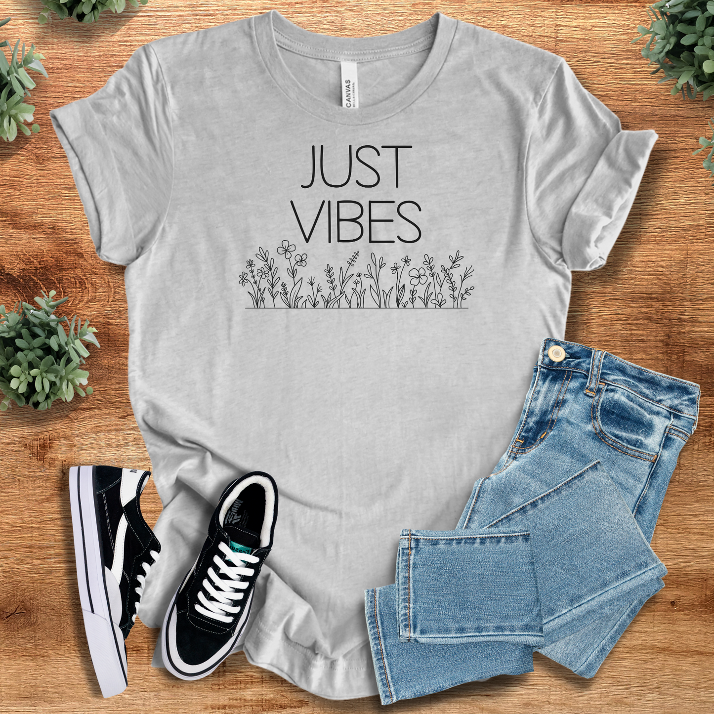 Heather gray Just Vibes Wildflower T‑Shirt on Bella+Canvas 3001. Comfy unisex tee with minimalist floral print, styled with jeans and shoes.