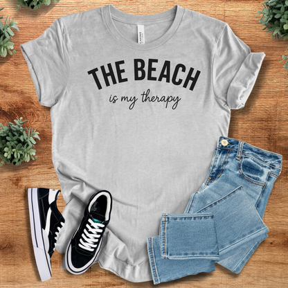 Heather-aqua t-shirt with '' text, flat lay styled on a wooden surface.