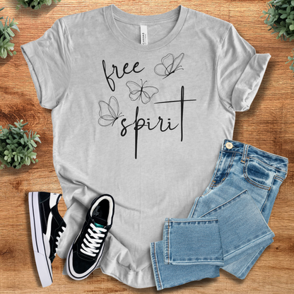Pink t-shirt with '' text, flat lay styled on a wooden surface.