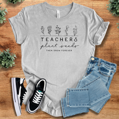 Heather-navy t-shirt with '' text, flat lay styled on a wooden surface.