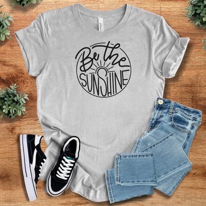 Yellow t-shirt with '' text, flat lay styled on a wooden surface.