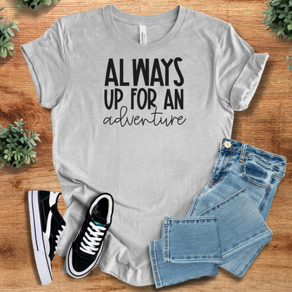 Heather-mauve t-shirt with '' text, flat lay styled on a wooden surface.