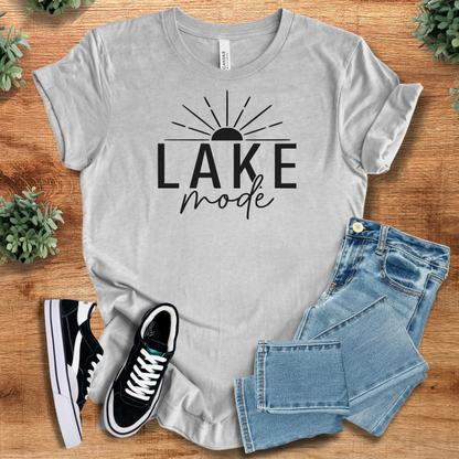 Heather-mauve t-shirt with '' text, flat lay styled on a wooden surface.