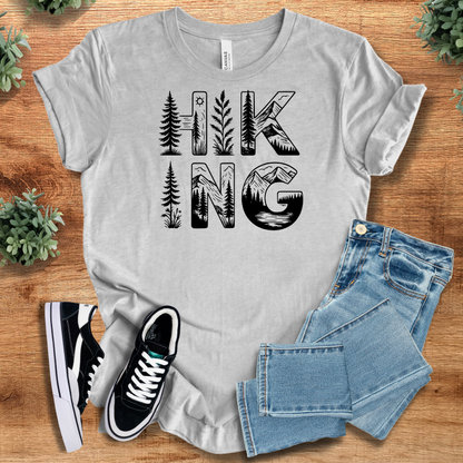 Athletic-heather t-shirt with 'Hiking Tee T‑Shirt' text, flat lay styled on a wooden surface.