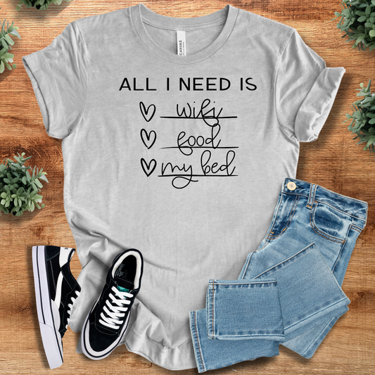 Wifi Food Bed T-Shirt in light gray with black handwritten-style print, paired with jeans and sneakers. Cozy tee for homebody fashion lovers.