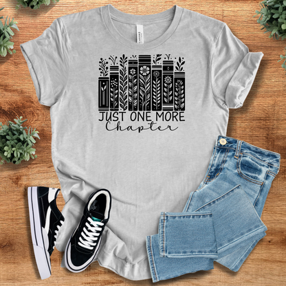 Heather-mauve t-shirt with '' text, flat lay styled on a wooden surface.