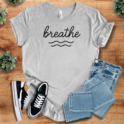 Heather-navy t-shirt with '' text, flat lay styled on a wooden surface.