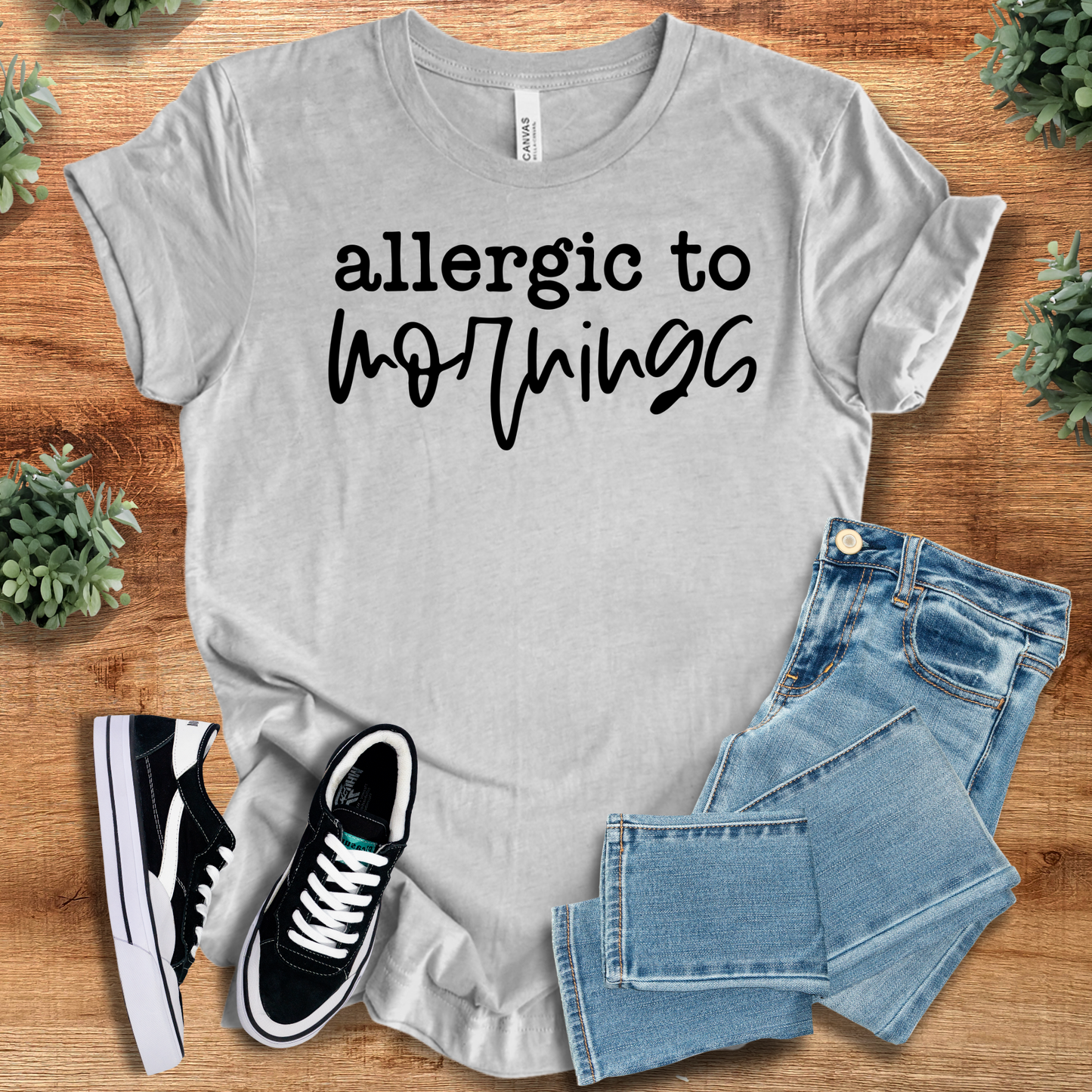 Heather-aqua t-shirt with '' text, flat lay styled on a wooden surface.