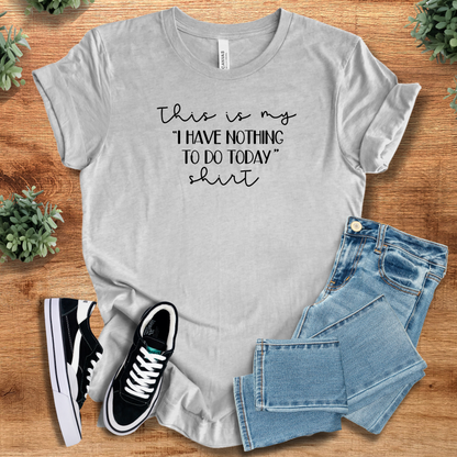 Yellow t-shirt with '' text, flat lay styled on a wooden surface.