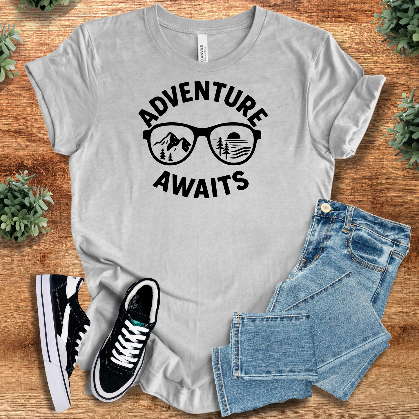Black t-shirt with '' text, flat lay styled on a wooden surface.