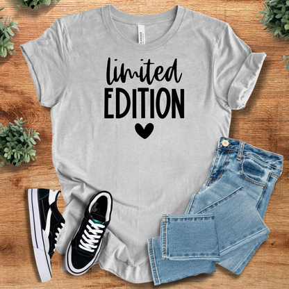 Heather-aqua t-shirt with '' text, flat lay styled on a wooden surface.