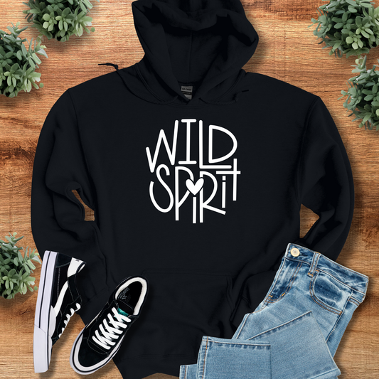 Wild Spirit Hoodie for Outdoor and Casual Wear in black with bold white graphic text, styled with jeans and sneakers on a rustic wood background.