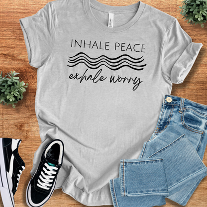 Heather-aqua t-shirt with '' text, flat lay styled on a wooden surface.