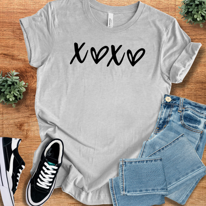 Heather-mauve t-shirt with '' text, flat lay styled on a wooden surface.