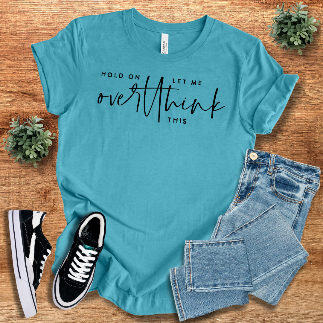 Teal blue 'Hold On Let Me Overthink This' t-shirt with black script text. Breathable cotton fabric, crew neck, and relaxed fit for daily wear.