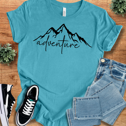 Heather-aqua t-shirt with '' text, flat lay styled on a wooden surface.