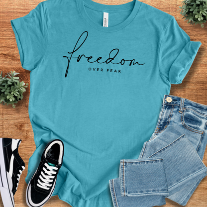 Heather-mauve t-shirt with '' text, flat lay styled on a wooden surface.