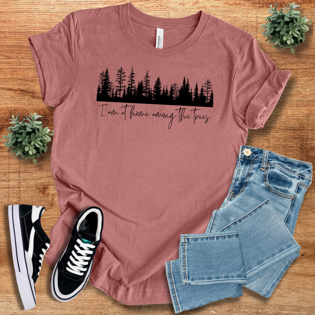 Mauve nature lover T-shirt with a black forest design and 'I'm At Home Among The Trees' text. A trendy and comfortable tee for outdoor lovers.