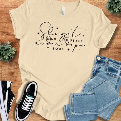 Heather-mauve t-shirt with '' text, flat lay styled on a wooden surface.
