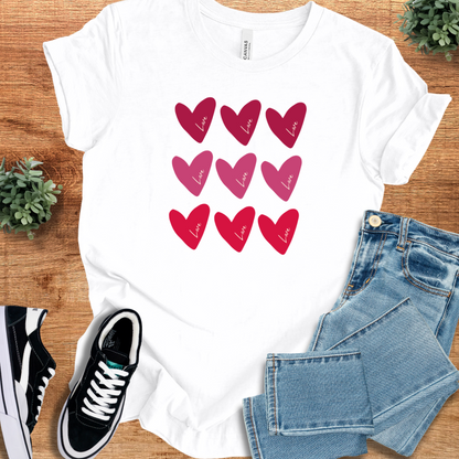 White Valentine Hearts T‑Shirt on Bella+Canvas 3001 with minimalist red and pink heart design, soft and comfy tee for gifting or everyday wear.