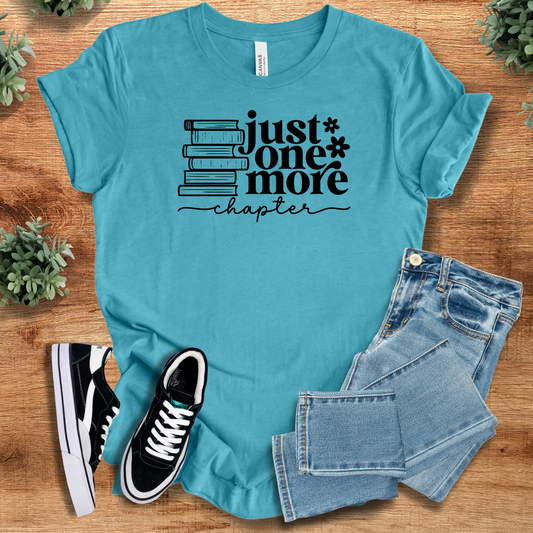 Aqua blue 'Just One More Chapter' shirt for book lovers, styled with jeans and sneakers. Cozy unisex tee ideal for reading nights.