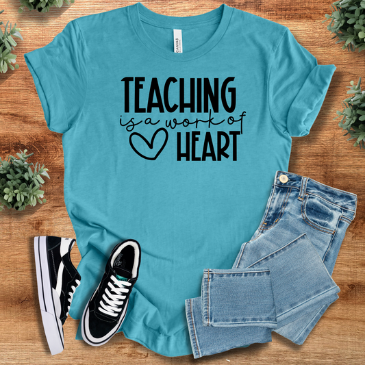 Aqua blue 'Teaching is a Work of Heart' T-shirt for educators, made from 100% cotton. Ideal teacher gift and classroom outfit.