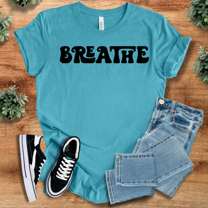 Heather-navy t-shirt with '' text, flat lay styled on a wooden surface.