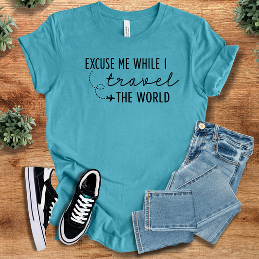 Excuse Me While I Travel the World T-Shirt in teal blue, 100% cotton travel tee styled with jeans and sneakers for adventurers.