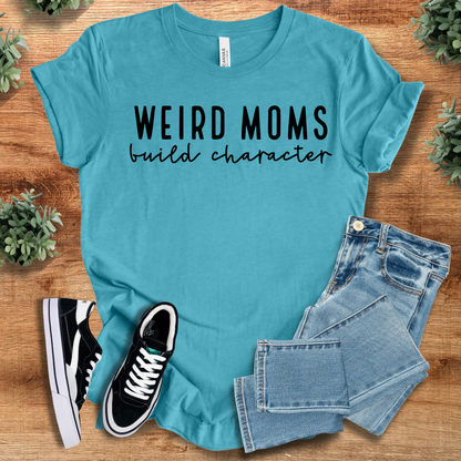 Heather-mauve t-shirt with '' text, flat lay styled on a wooden surface.