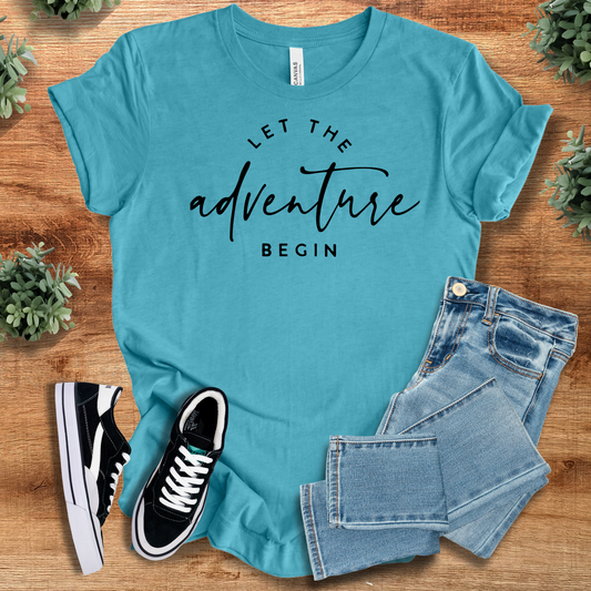 Let The Adventure Begin T‑Shirt in aqua blue on soft Bella+Canvas 3001 fabric, styled with jeans and sneakers. Minimalist nature-inspired tee.