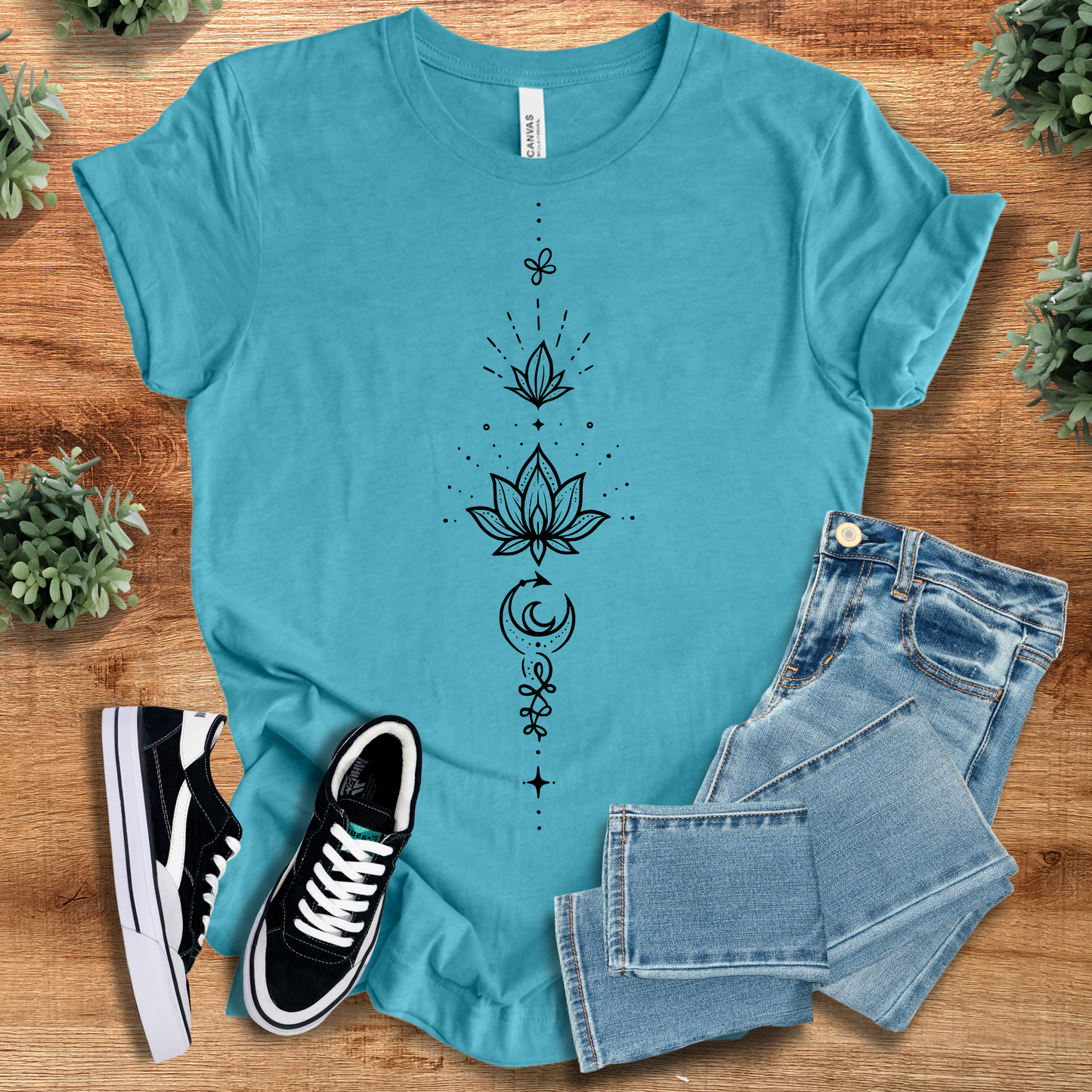 Black t-shirt with '' text, flat lay styled on a wooden surface.