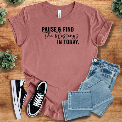 Heather-navy t-shirt with '' text, flat lay styled on a wooden surface.
