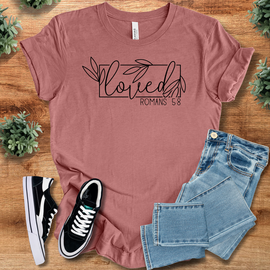 Loved Romans 5:8 Tee in mauve with floral script design, Christian Faith T-Shirt for women and men, styled with jeans and sneakers.