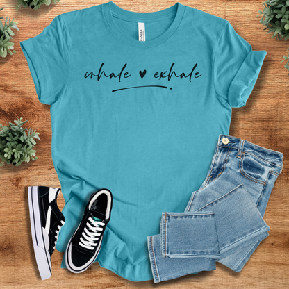 Heather-navy t-shirt with '' text, flat lay styled on a wooden surface.