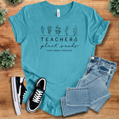 Heather-navy t-shirt with '' text, flat lay styled on a wooden surface.