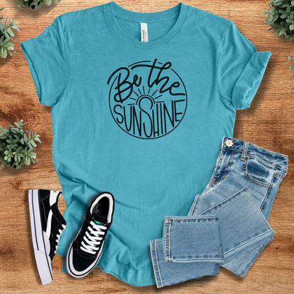 Yellow t-shirt with '' text, flat lay styled on a wooden surface.