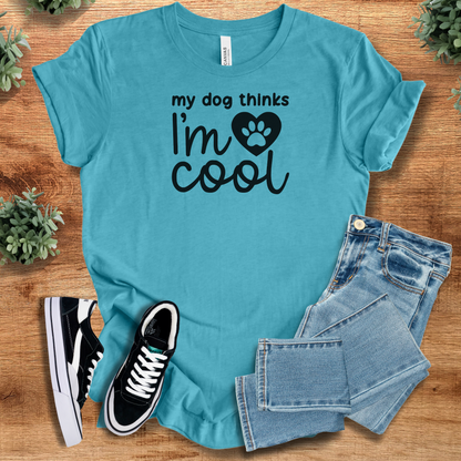 Heather-aqua t-shirt with 'My Dog Thinks I'm Cool T‑Shirt' text, flat lay styled on a wooden surface.