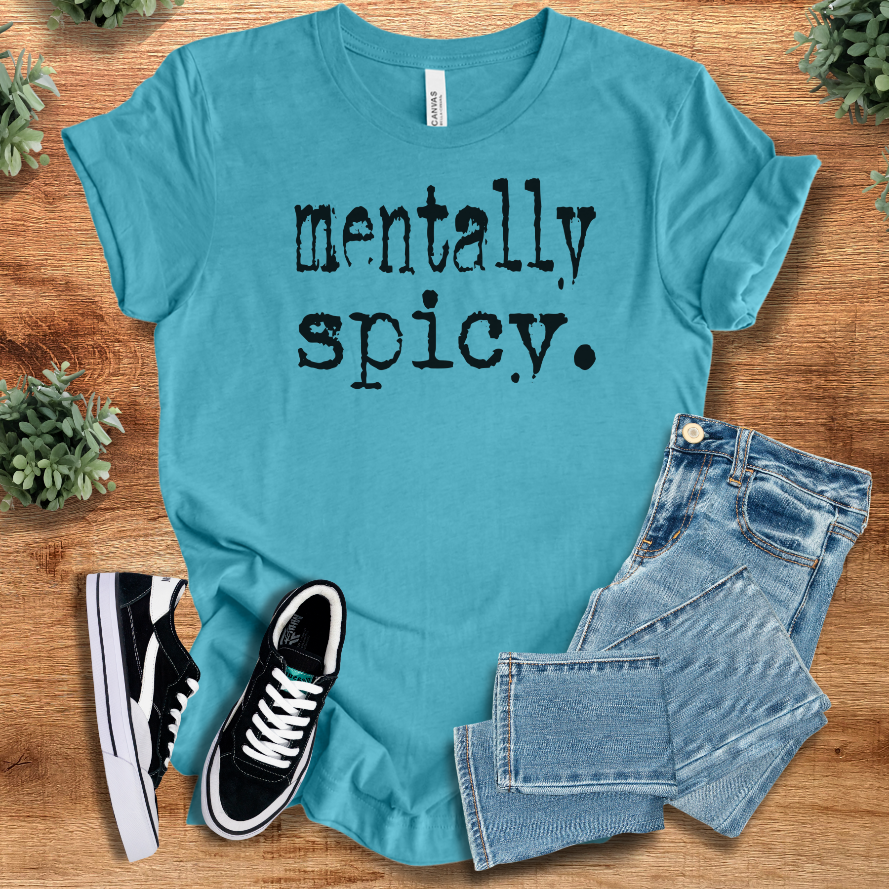 Mentally Spicy. T‑Shirt in aqua blue on soft Bella+Canvas 3001 fabric, styled with jeans and sneakers. Minimalist graphic tee for casual wear.