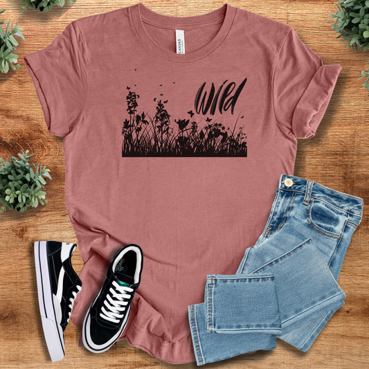 Wild With Wildflowers T‑Shirt in mauve on soft Bella+Canvas 3001 tee featuring black wildflower silhouette and 'Wild' text. Minimalist nature design.
