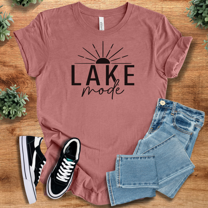 Heather-mauve t-shirt with 'Lake Mode Summer T‑Shirt' text, flat lay styled on a wooden surface.