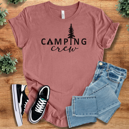 Pink t-shirt with '' text, flat lay styled on a wooden surface.