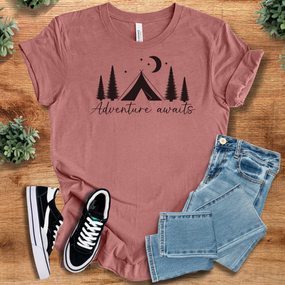 Military-green t-shirt with '' text, flat lay styled on a wooden surface.