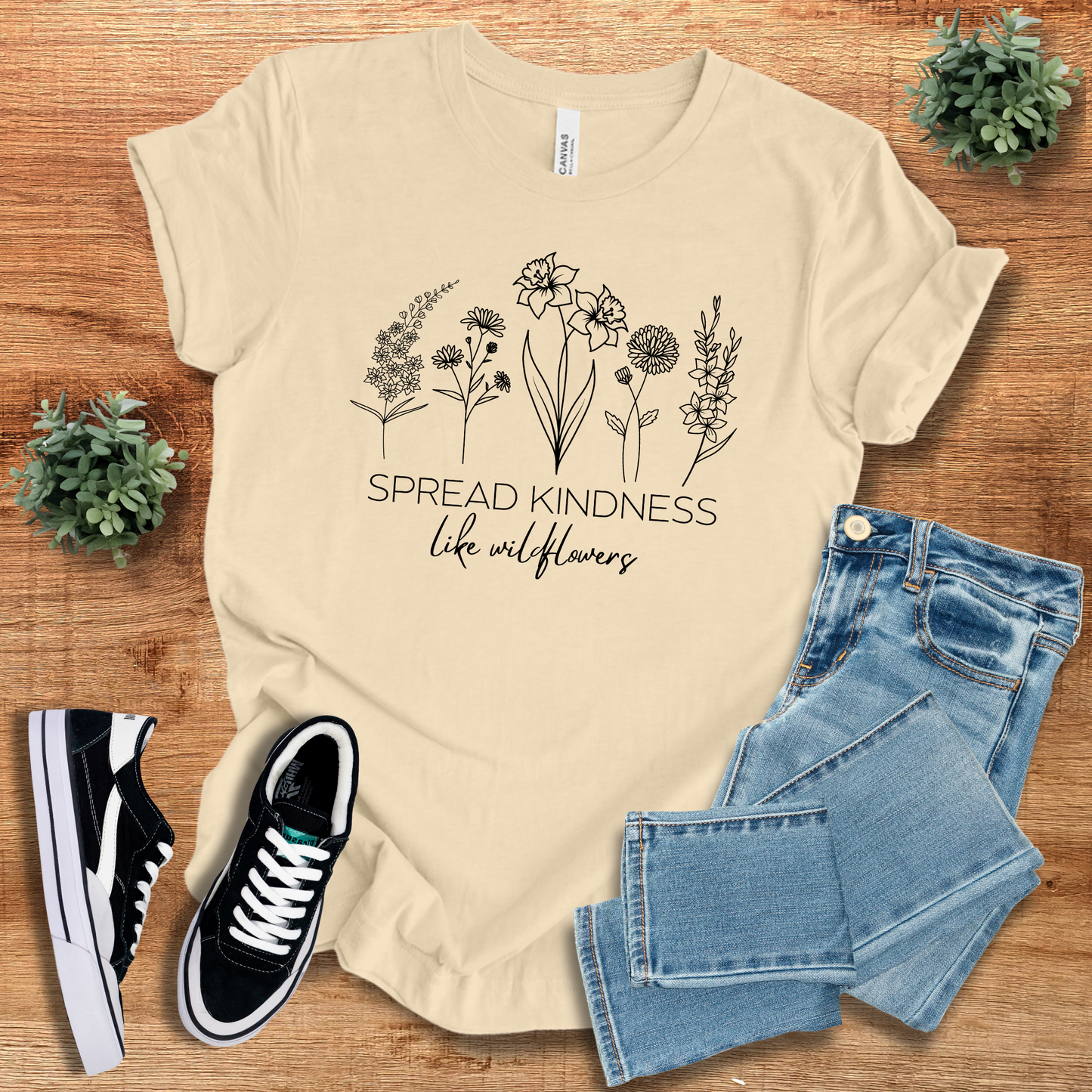 Cream Spread Kindness Like Wildflowers T-Shirt featuring a minimalist floral print. Sustainable and comfortable unisex cotton tee for casual wear.
