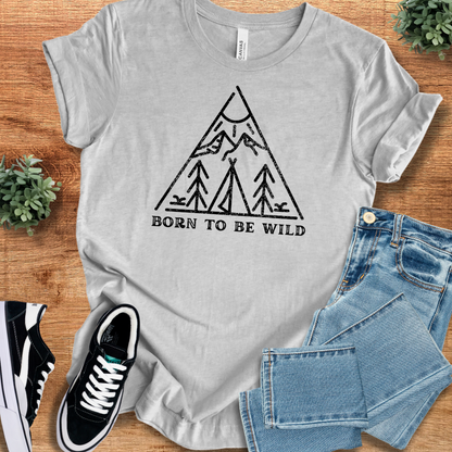 Athletic-heather t-shirt with 'Born To Be Wild T‑Shirt' text, flat lay styled on a wooden surface.