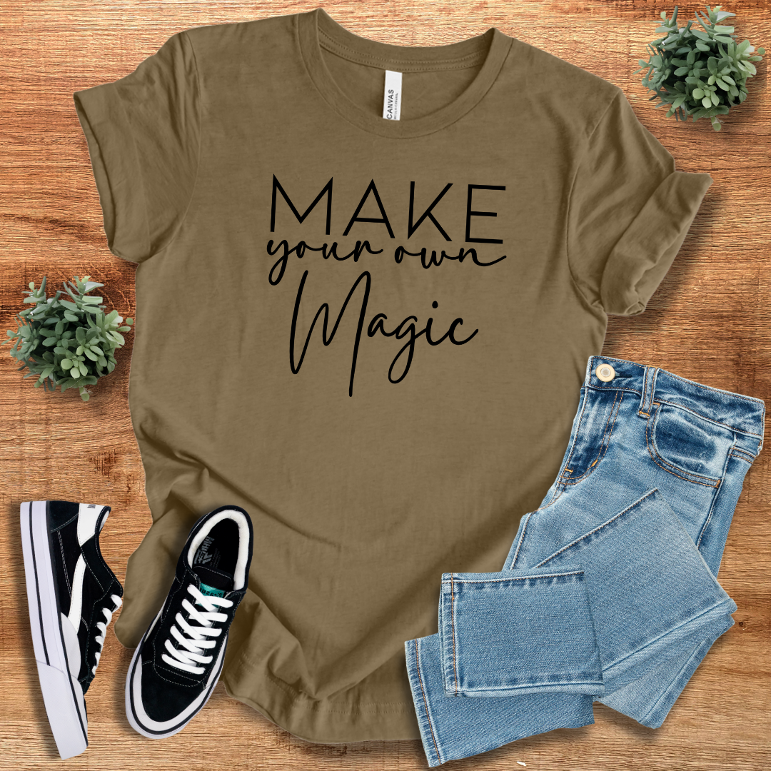 Brown 'Make Your Own Magic' unisex t-shirt with black script text, paired with denim jeans and sneakers. Sustainable, breathable cotton tee for everyday wear.