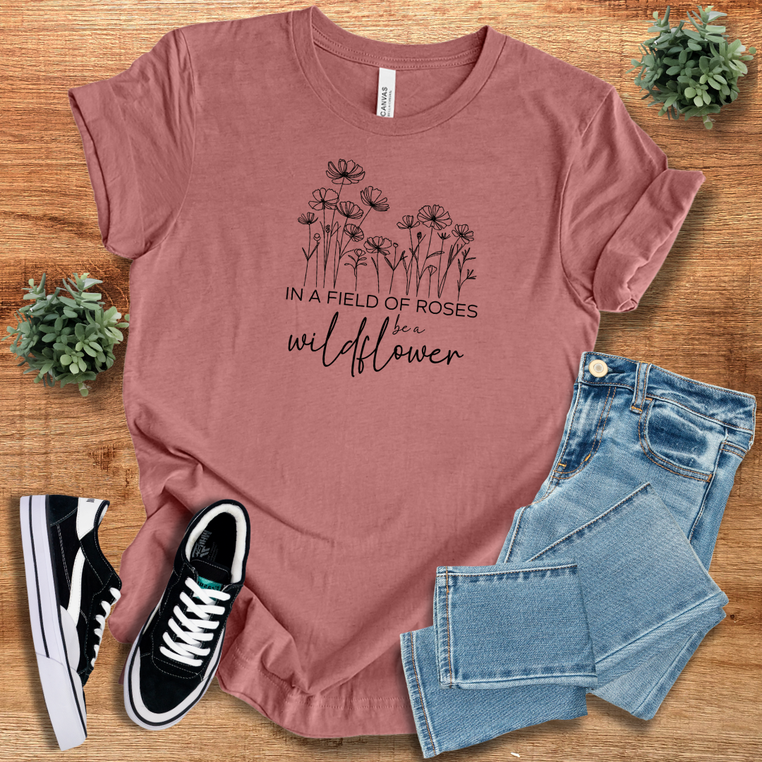 Mauve 'In A Field Of Roses Be A Wildflower' t-shirt featuring a floral graphic, casual fit, and lightweight cotton fabric.